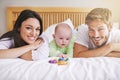 Portrait, mother and father with baby on bed for love, care and quality time together. Happy parents, family and newborn Royalty Free Stock Photo