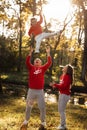 Portrait of a mother, father holds, throws up and spins the daughter on hands walking on nature on autumn day vacation. Mom, dad Royalty Free Stock Photo