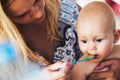 Portrait of mother feeding her baby with spoon Royalty Free Stock Photo