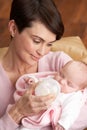 Portrait Of Mother Feeding Newborn Baby At Home