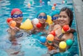 A portrait of a mother and her children playing ball in the pool Royalty Free Stock Photo