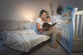 Portrait of mother holding baby boy on knees and reading him a b Royalty Free Stock Photo