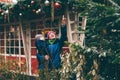 Portrait of mother holding child in her arms and admiring Christmas tree outdoor.