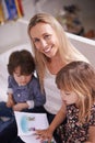 Portrait, mother and kids on sofa with book for bonding, teaching and learning together in home. Mom, son and daughter Royalty Free Stock Photo