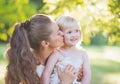 Portrait of mother kissing baby outdoors Royalty Free Stock Photo