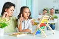 Portrait of mother with little daughter counting with abacus Royalty Free Stock Photo