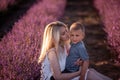 Portrait mother with little son are sitting in purple lavender field. Concept of allergy, travel