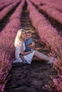 Portrait mother with little son are sitting in purple lavender field. Concept of allergy, travel