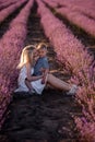 Portrait mother with little son are sitting in purple lavender field. Concept of allergy, travel