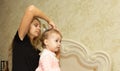 Portrait of mother makes a beautiful hairstyle for her daughter Royalty Free Stock Photo