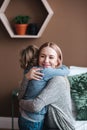 Portrait of mother and son hugging smiling intdoors. Positive relations. Mum and son together.