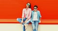 Portrait of mother with son teenager in sunglasses, checkered shirts on an orange background Royalty Free Stock Photo