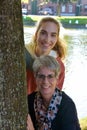 Portrait of mother and teenage daughter behind a tree Royalty Free Stock Photo