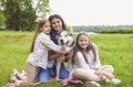 Portrait of a mother and two daughters with a husky dog smiling looking at the camera in a summer park. Royalty Free Stock Photo