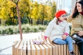 Portrait of mother who sitting on bench outdoor with cute beautiful disabled daughter and smiling, communication to each