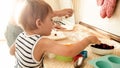 Portrait of mother with 3 years toddler son baking cookies on kitchen at morning. Family baking and cooking at home Royalty Free Stock Photo