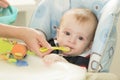 Portrait of mothers hand giving food in spoon to her baby boy Royalty Free Stock Photo