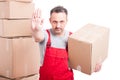 Portrait of mover man holding box showing stop gesture