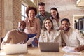 Portrait Of Multi-Cultural Business Team Meeting Around Laptop In Busy Office Royalty Free Stock Photo