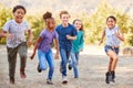 Portrait Of Multi-Cultural Children With Friends RunnIng Towards Camera In Countryside Together Royalty Free Stock Photo