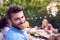 Portrait Of Multi-Cultural Friends At Home Sitting At Table Enjoying Summer Garden Party Royalty Free Stock Photo