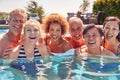 Portrait Of Multi-Cultural Group Of Senior Friends Relaxing In Outdoor Pool On Summer Vacation Royalty Free Stock Photo