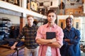 Portrait Of Multi-Cultural Male Sales Team In Fashion Store Standing In Front Of Clothing Display