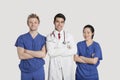 Portrait of multi ethnic healthcare professionals standing with arms crossed over gray background Royalty Free Stock Photo