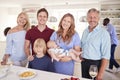 Portrait Of Multi-Generation Family And Friends Gathering In Kitchen For Celebration Party Royalty Free Stock Photo