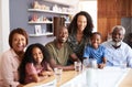 Portrait Of Multi-Generation Family Sitting Around Table At Home Enjoying Meal Together Royalty Free Stock Photo