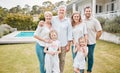 Portrait of multi-generation family standing together outside by the pool at home on a sunny day and smiling at the Royalty Free Stock Photo