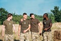 portrait of multicultural smiling soldiers in military uniform on range