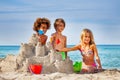 Happy friends making sandcastle on the beach Royalty Free Stock Photo