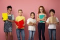 Portrait of multiethnic kids with textbooks and notebooks ready to start new school year over pink background