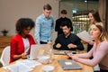 Portrait of multiethnic male and female colleagues working with project documents at meeting in boardroom, sitting at Royalty Free Stock Photo