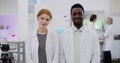 Portrait of multiethnic young scientists smiling at camera in modern laboratory Royalty Free Stock Photo