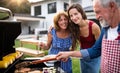 Portrait of multigeneration family outdoors on garden barbecue, grilling. Royalty Free Stock Photo