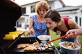 Portrait of multigeneration family outdoors on garden barbecue, grilling. Royalty Free Stock Photo