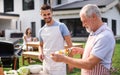 Portrait of multigeneration family outdoors on garden barbecue, grilling. Royalty Free Stock Photo