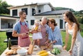 Portrait of multigeneration family outdoors on garden barbecue, grilling. Royalty Free Stock Photo