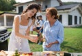 Portrait of multigeneration family outdoors on garden barbecue, grilling. Royalty Free Stock Photo