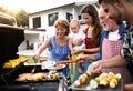 Portrait of multigeneration family outdoors on garden barbecue, grilling. Royalty Free Stock Photo