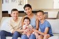 Portrait of a multiracial family at home. Mother with her adoptive sons. Young mother relaxing with her children. Mixed