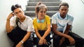 Portrait of multiracial group of teen high school students sitting on stairs looking at camera. Horizontal banner image