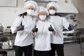 Portrait of multiracial team of three chefs standing together on kitchen Royalty Free Stock Photo