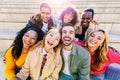 Portrait of multiracial young group of happy people laughing at camera together Royalty Free Stock Photo