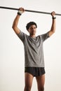 Portrait of a muscular black athlete grabbing carbon pullup bar