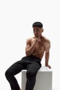 Portrait of muscular, handsome, young, asian man posing shirtless in trousers against white studio background Royalty Free Stock Photo