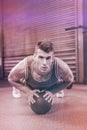 Portrait of muscular man doing pull up with medicine ball Royalty Free Stock Photo