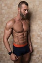 Portrait of Muscular Man Standing Near the Wall Royalty Free Stock Photo